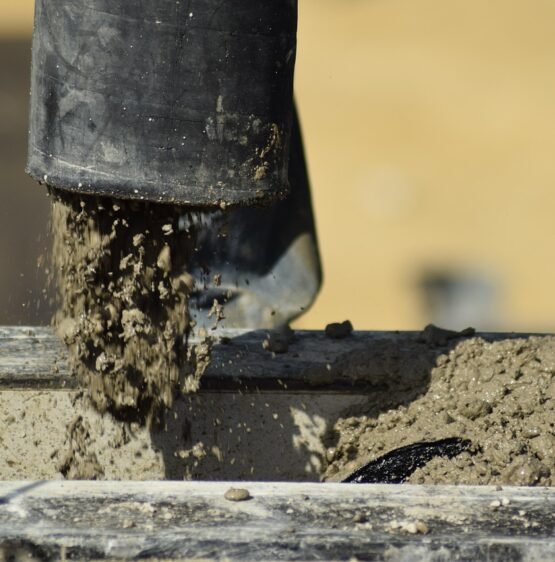 Concrete being poured from a pump into a construction site, showcasing professional concrete work relevant to Tomas's Concrete services in Sacramento.